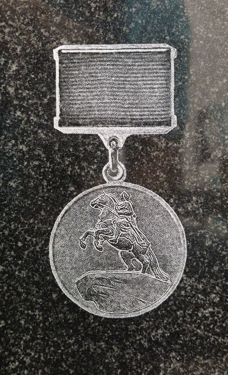 Полированный чёрный гранит с крапом, крупный план гравировки наградного знака